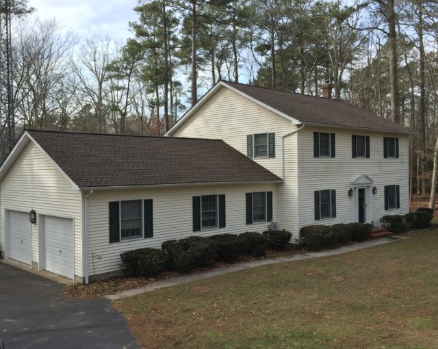 large white home with asphalt shingles and two car garage