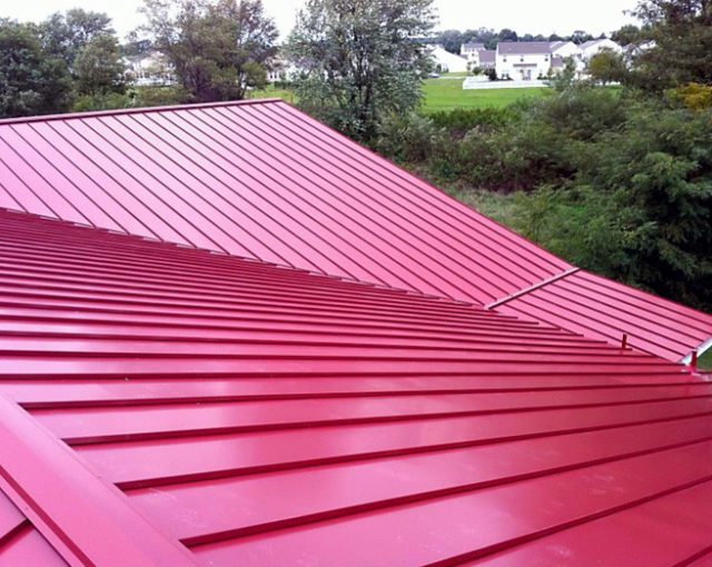 red metal roof sitting in front of trees