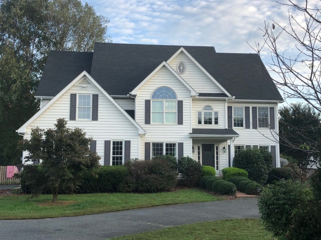 A white home with grey shingles installed by a roofing company in Maryland