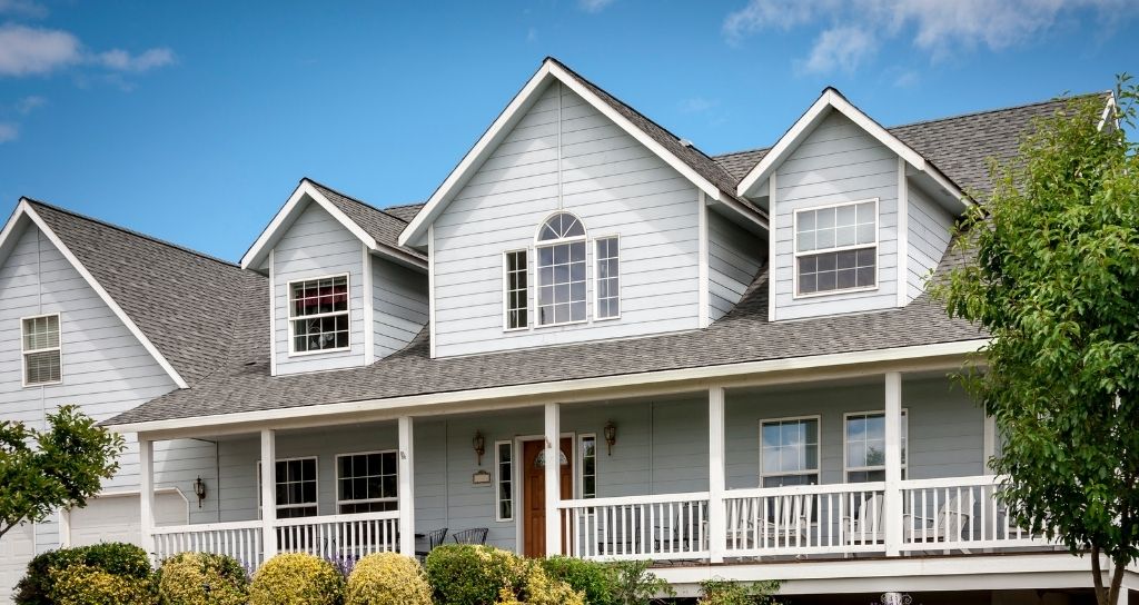 Craftsman home with gray siding and black shingle roof